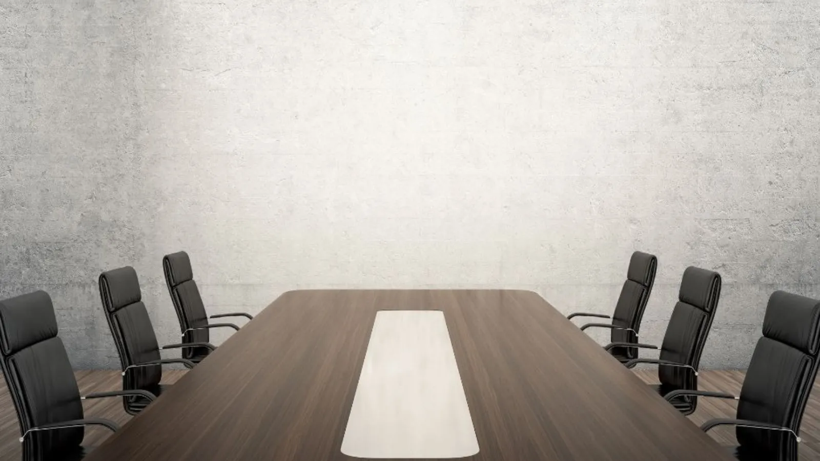 An empty boardroom with a long dark wood table, black leather chairs and a pale concrete wall.